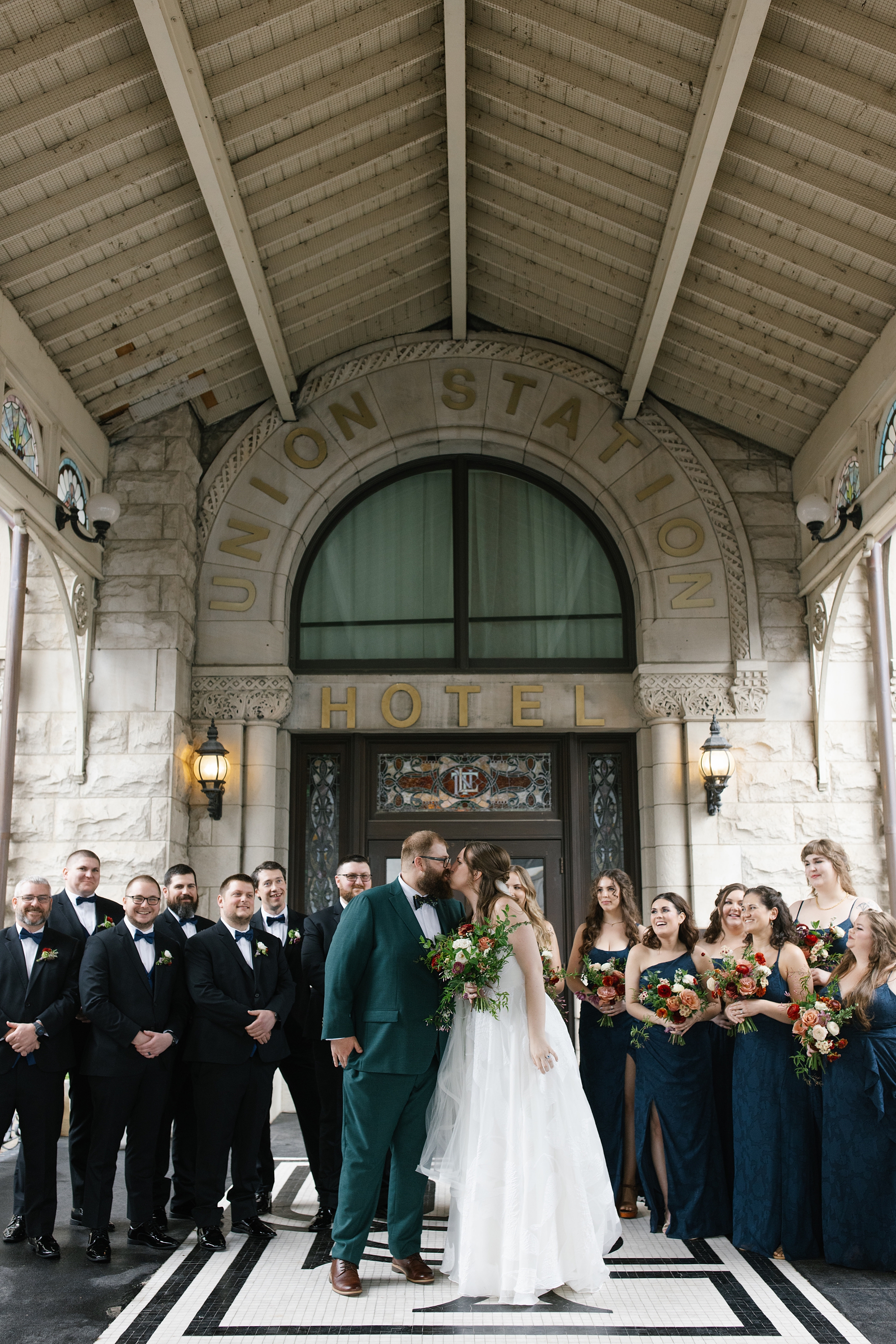 bride and groom kiss with wedding party beside them from Vintage Wedding Details at Union Station Hotel