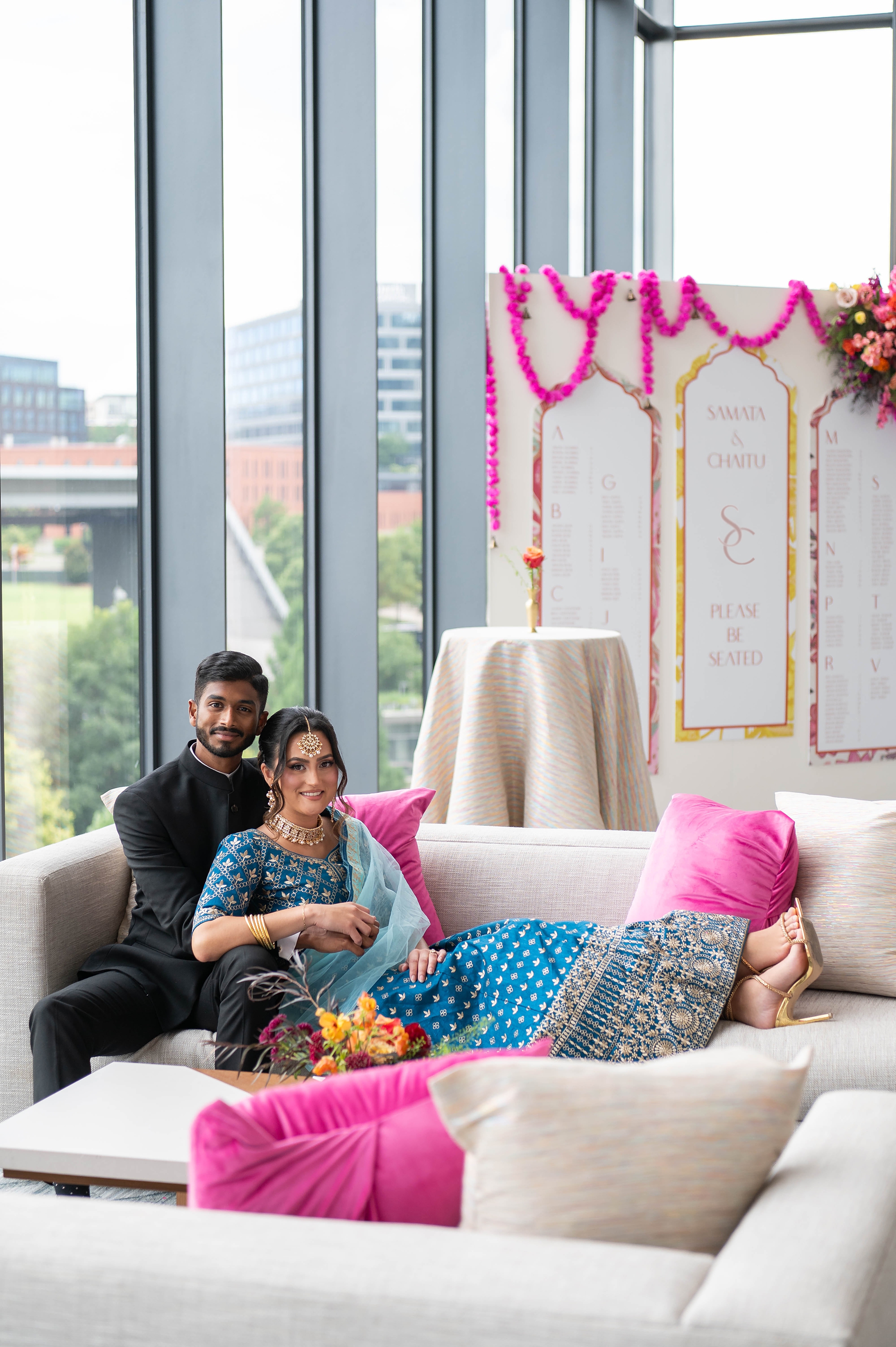 couple sit on couch with colorful seating chart in the background at Four Seasons Hotel in Nashville