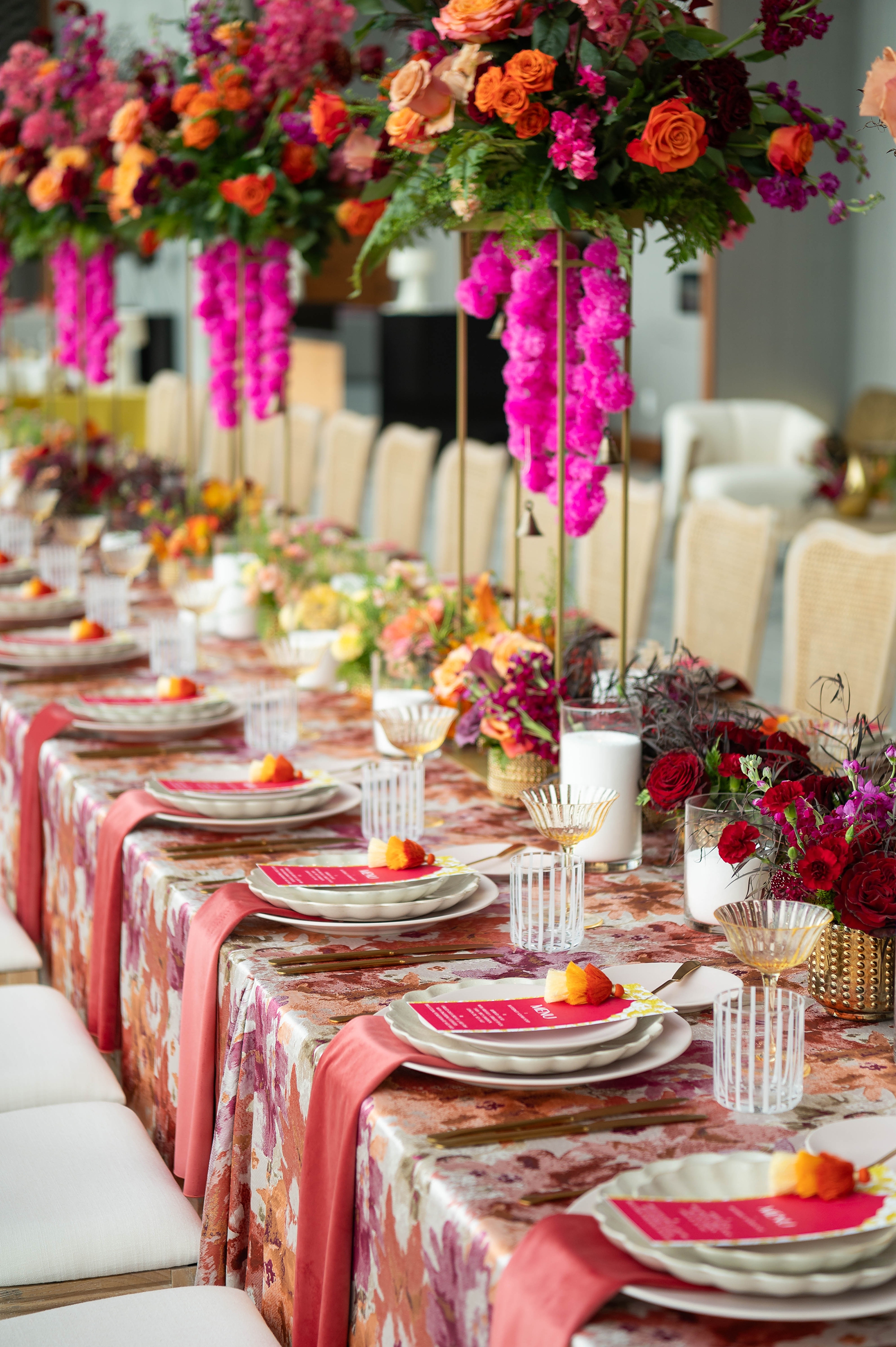 high sitting floral centerpieces on tablescape with colorful menus and linens
