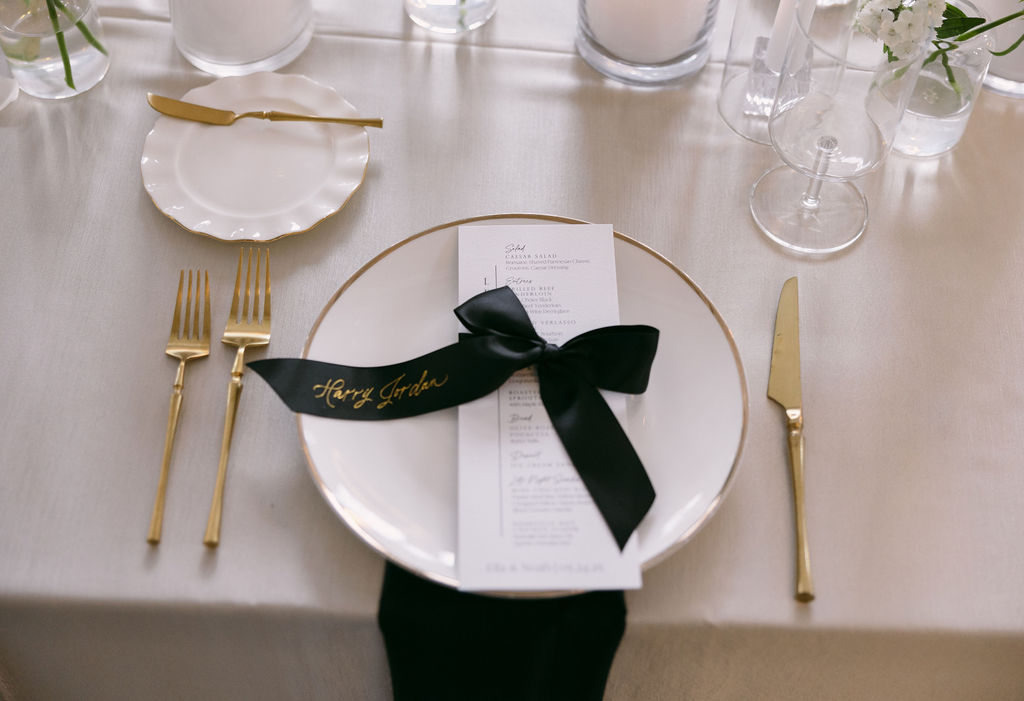 black satin ribbon place cards tied around white menus at place setting at Diamond Creek Farms Wedding