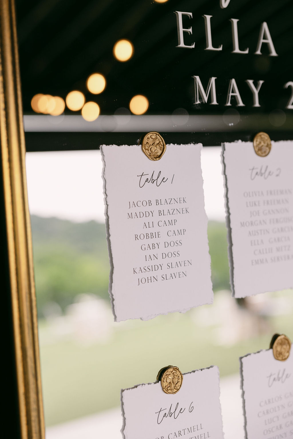 table assignments on handmade paper attached to mirror with gold wax seal