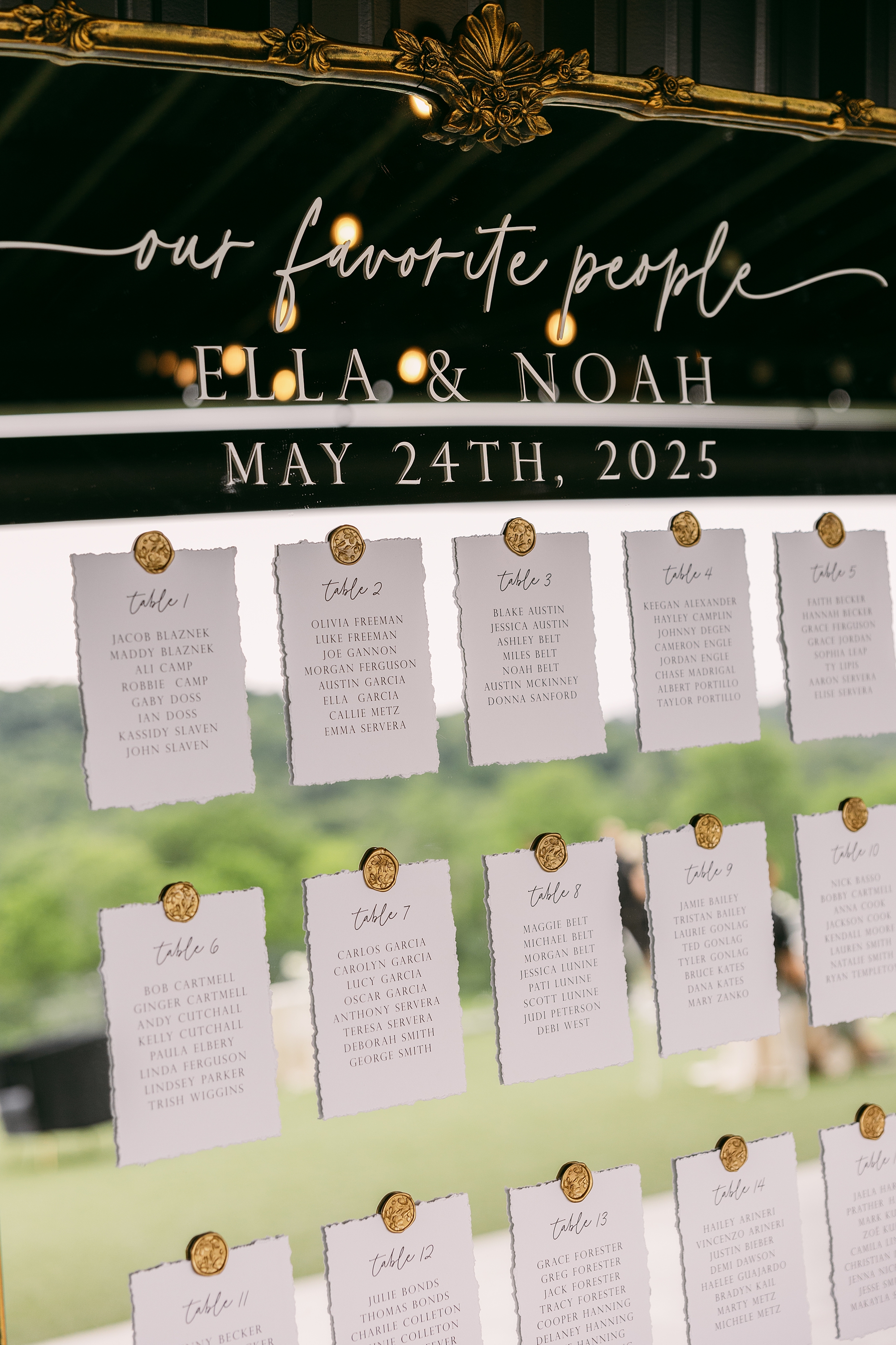 table assignments on handmade paper attached to gold framed mirror with gold wax seal