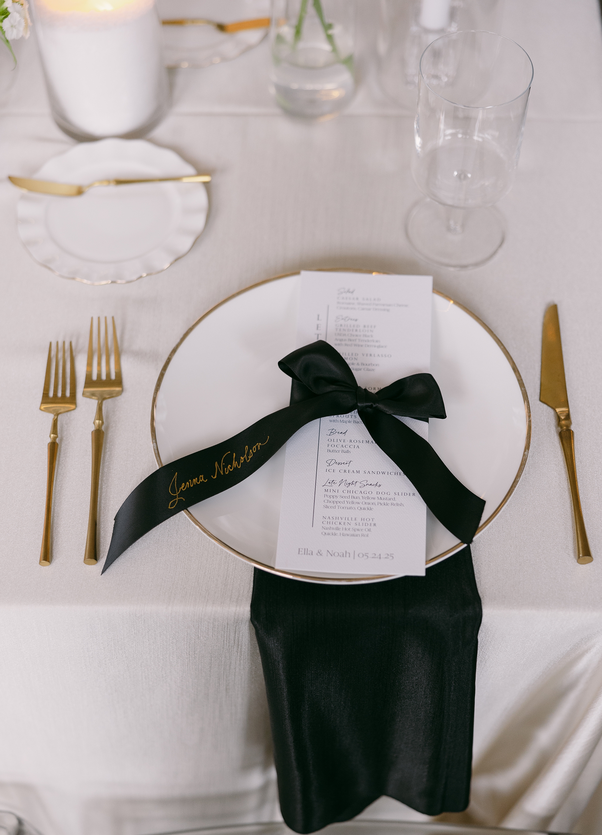 black satin ribbon place cards tied around white menus 