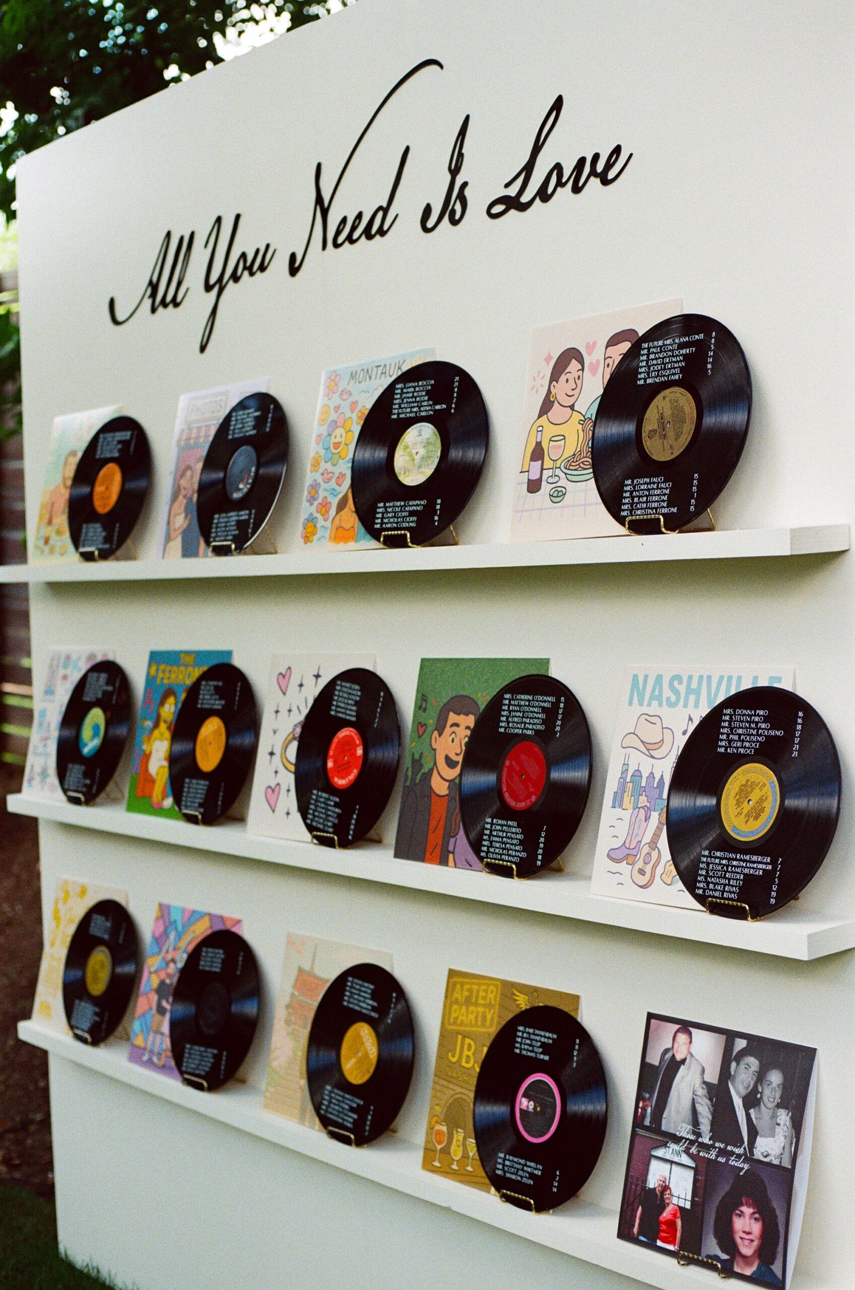 custom seating chart using vinyl records that listed names and table assignment. album covers featured custom artwork displaying moments from couple love story