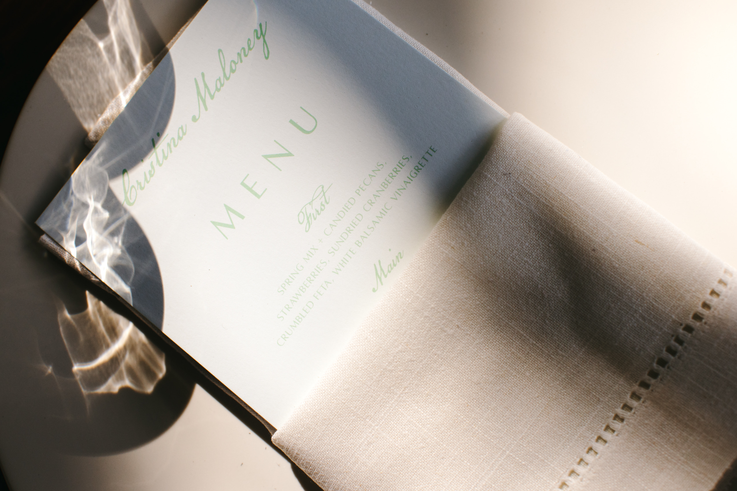 custom wedding menu tucked into light pink naplkin