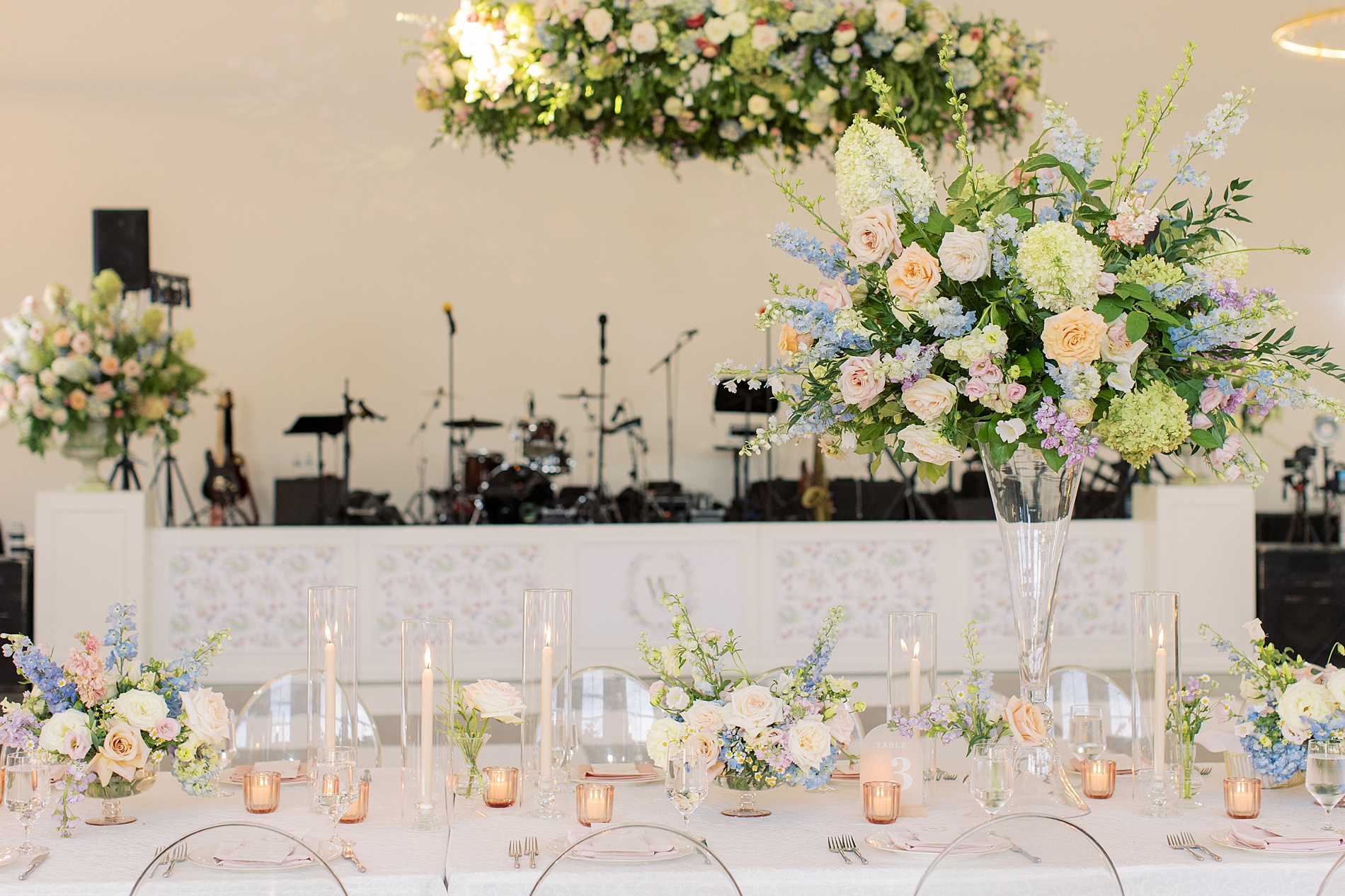 Custom floral artwork from envelope liners on stage front at reception