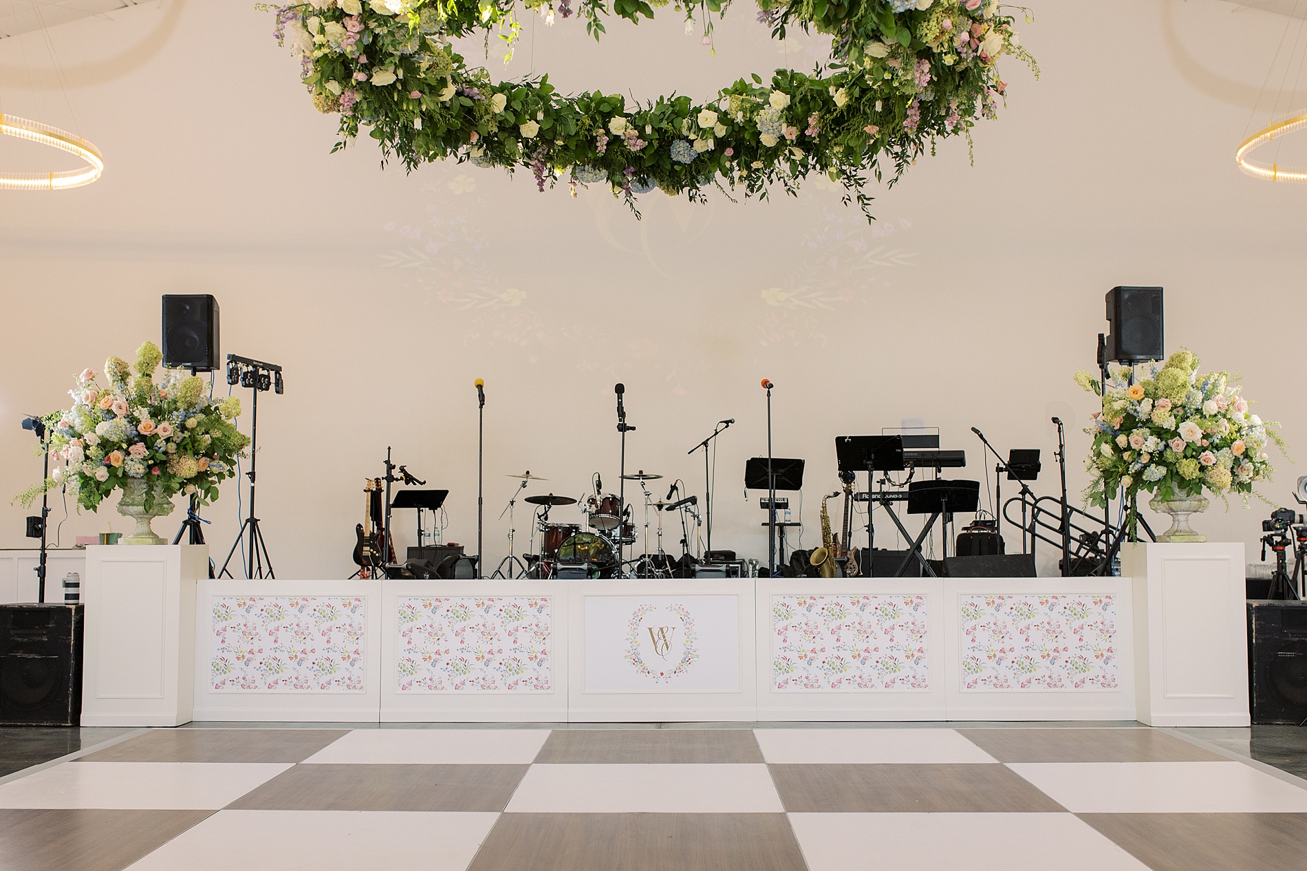 Custom floral artwork from envelope liners on stage front at reception