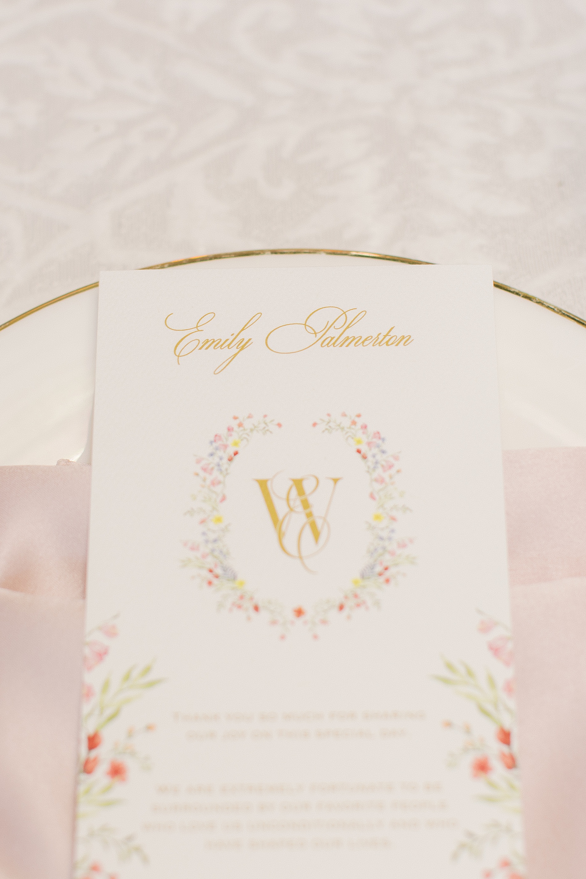 Custom floral artwork from envelope liners on wedding menus at reception