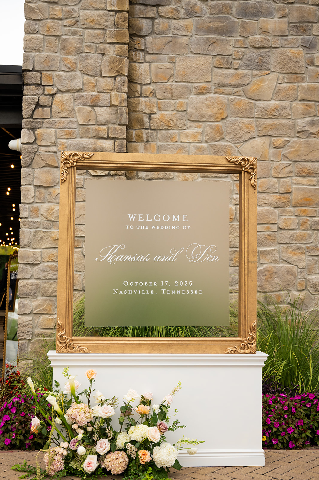wedding welcome sign in frosted glass with white calligraphy and framed in gold on white stand