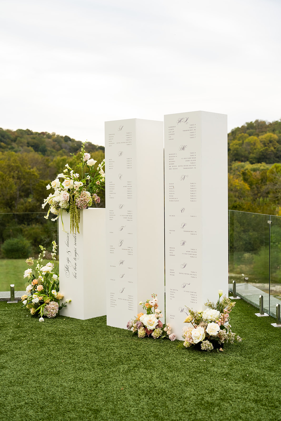 white seating chart installation in columns with black calligraphy 