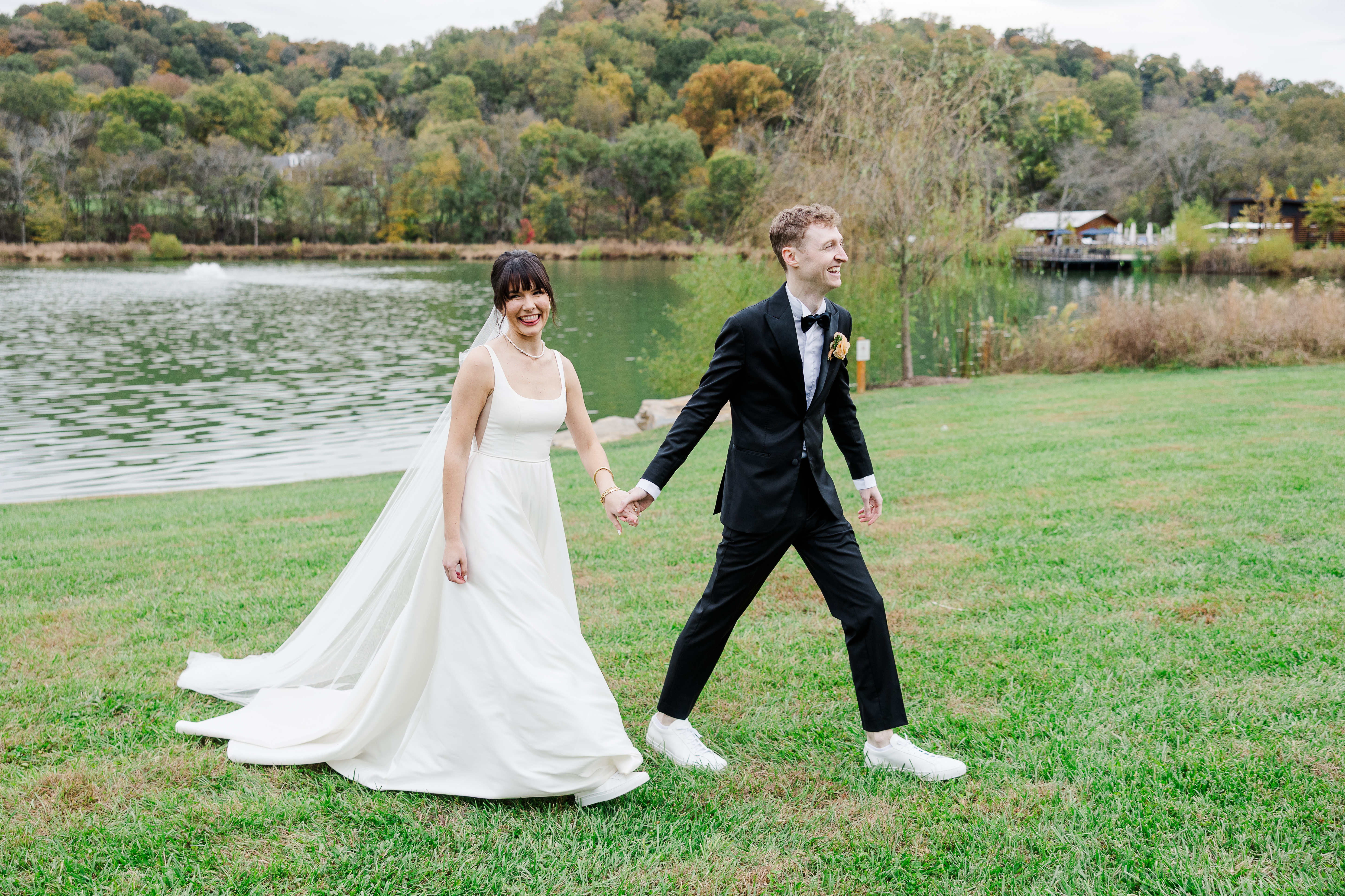 bride and groom walking by pond at Southall Farm & Inn wedding venue
