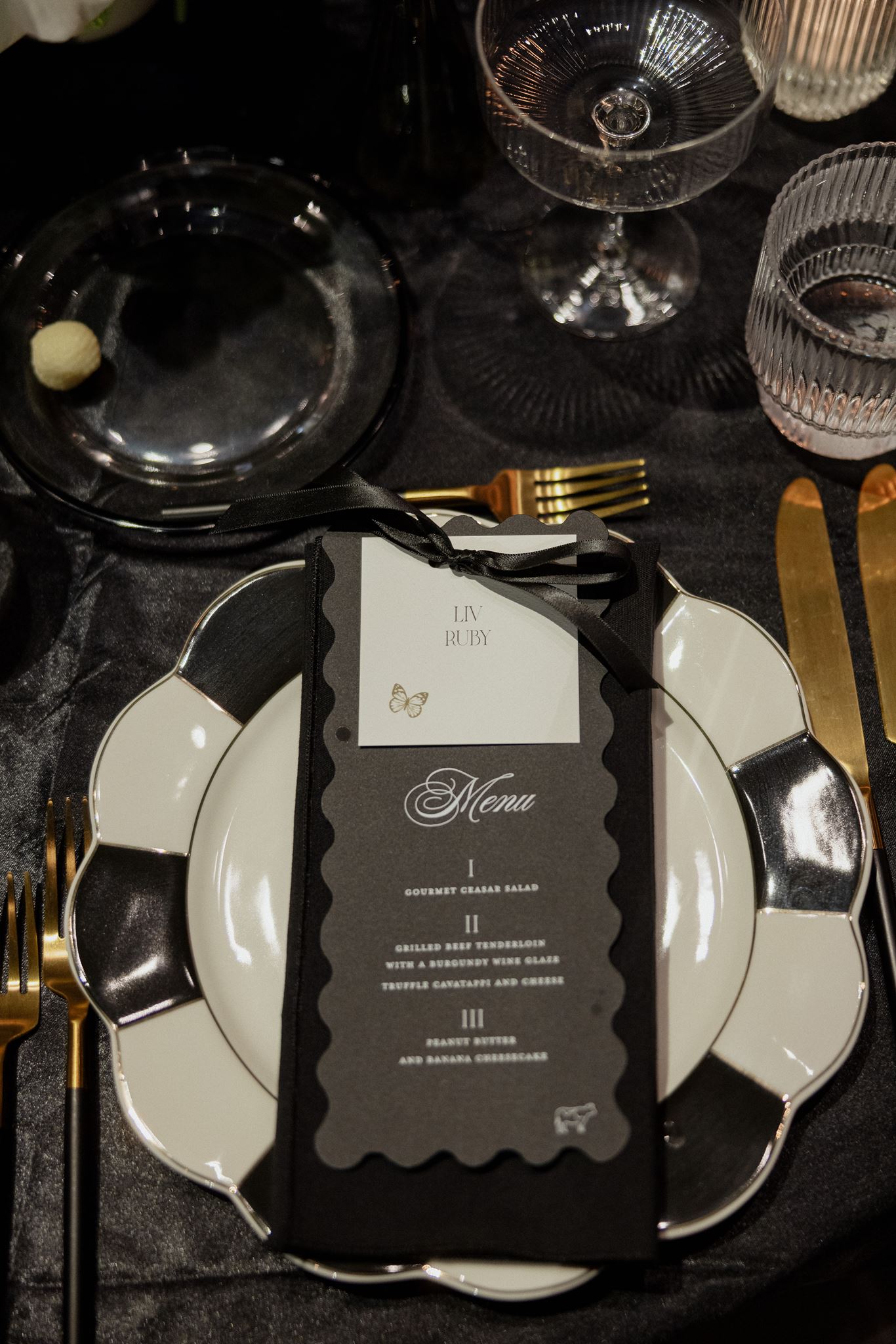 wavy die cut black menus with white place card attached by black ribbon  created by Nashville wedding design house, White Ink Calligraphy 