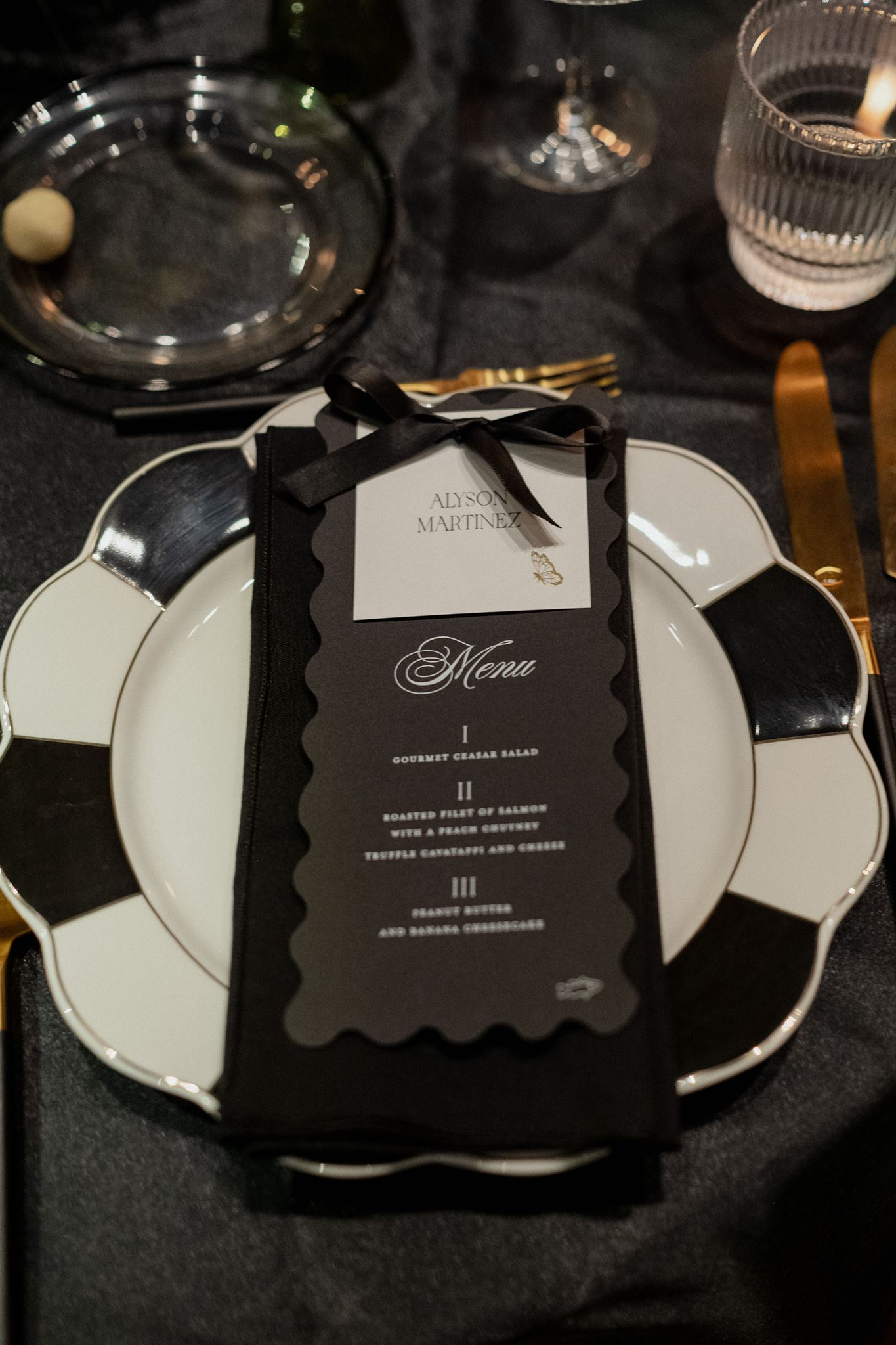 wavy die cut black menus with white place card attached by black ribbon 