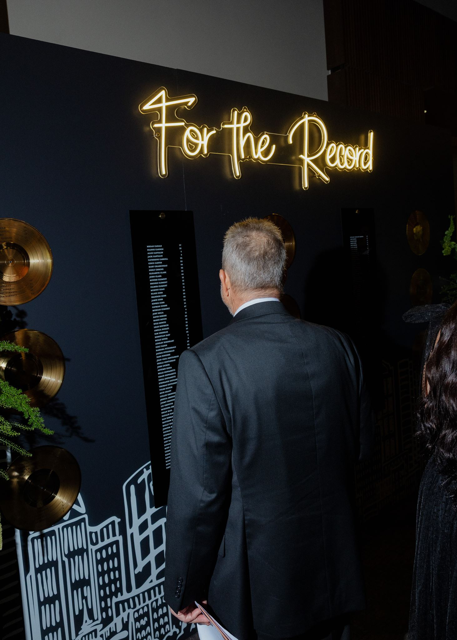Neon sign at top of seating chart reading "For the Record" 