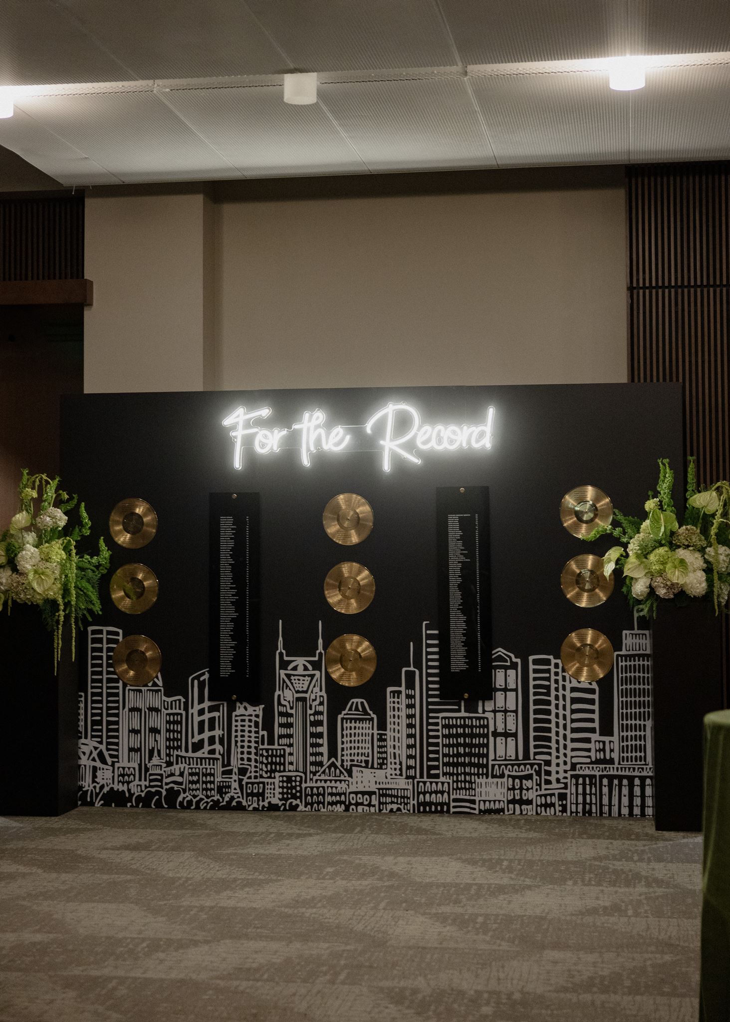 A music city seating chart featuring  Nashville skyline, neon sign, and gold vinyl records displaying seating arrangements for classic black and white wedding at Country Music Hall of Fame 