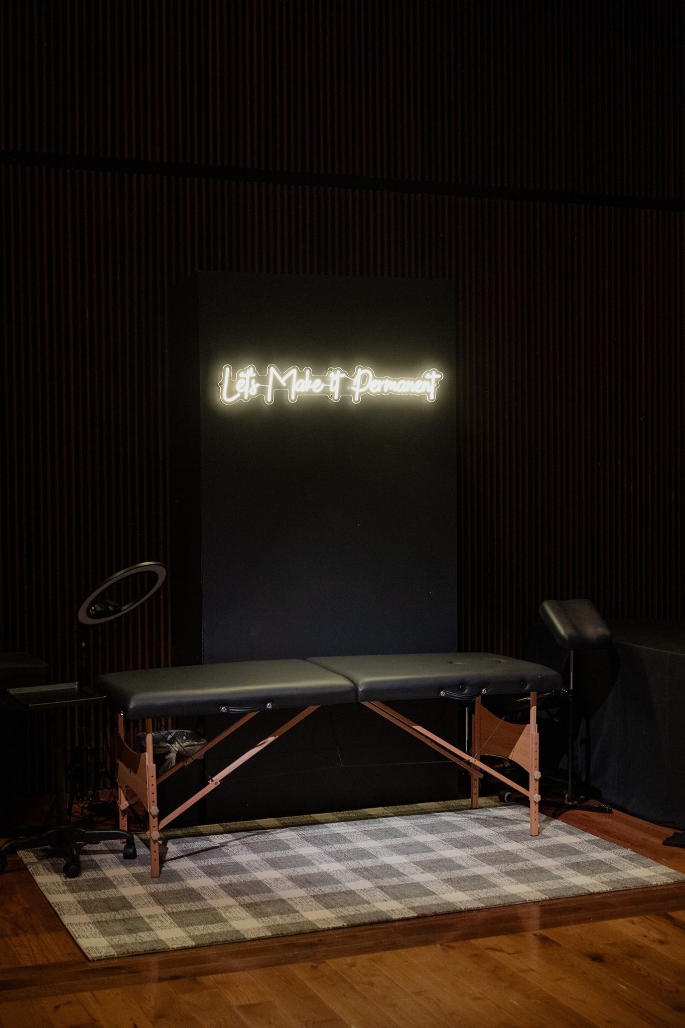 Neon sign reading "Lets Make it Permanent" for tattoo station at wedding reception 