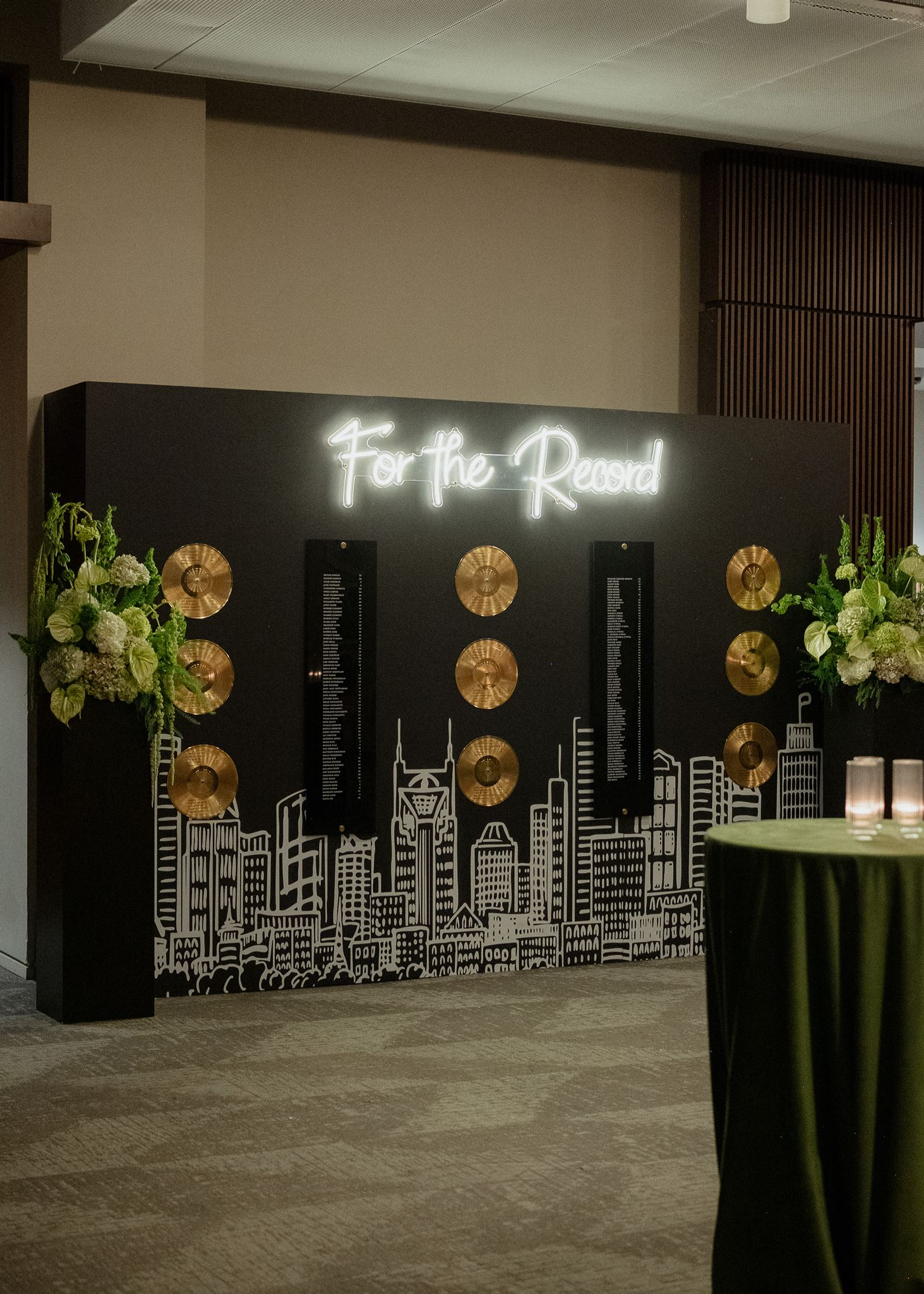 A music city seating chart featuring  Nashville skyline, neon sign, and gold vinyl records displaying seating arrangements for classic black and white wedding at Country Music Hall of Fame 