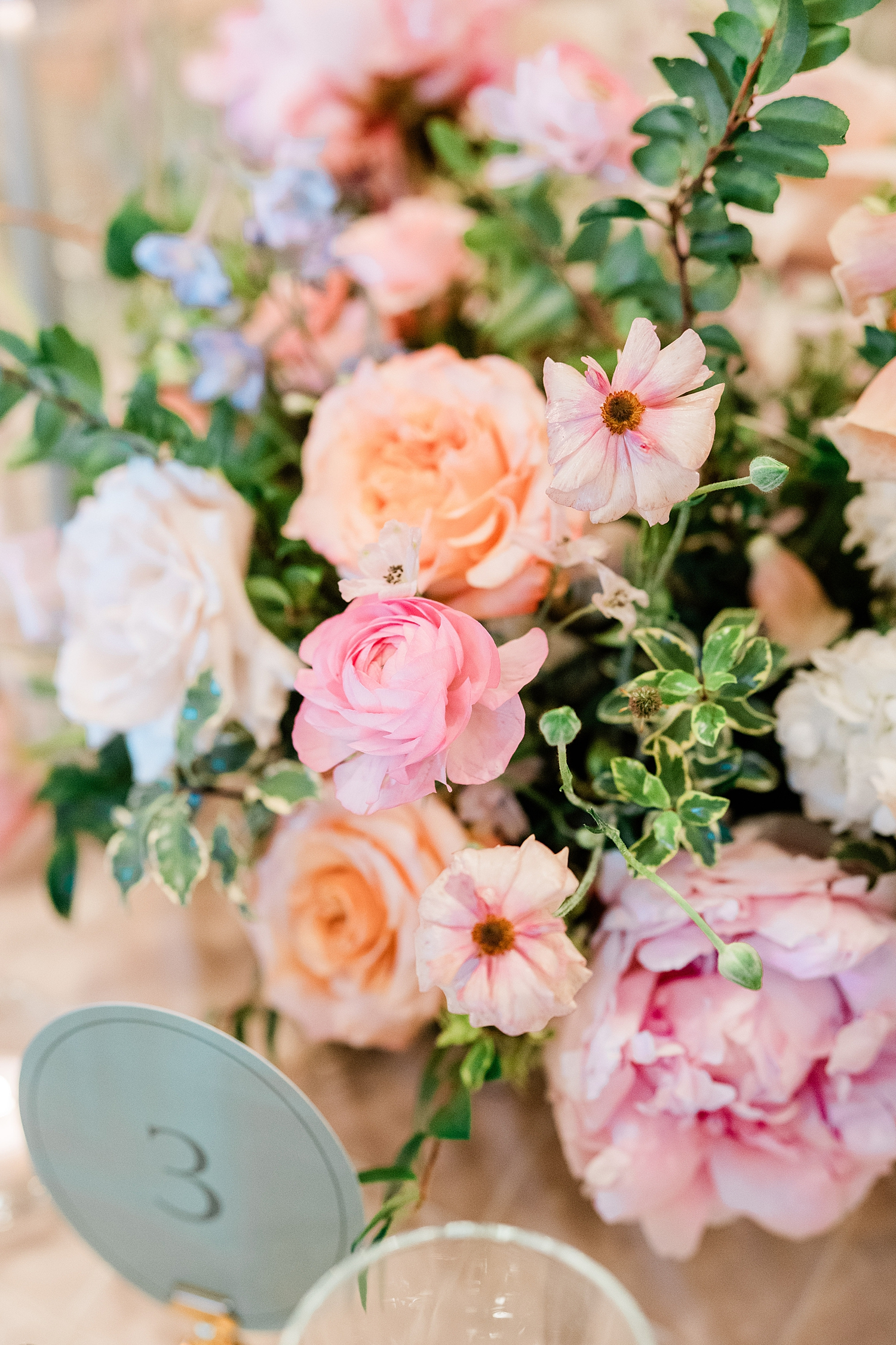 green table numbers with gold card holder by spring floral arrangements