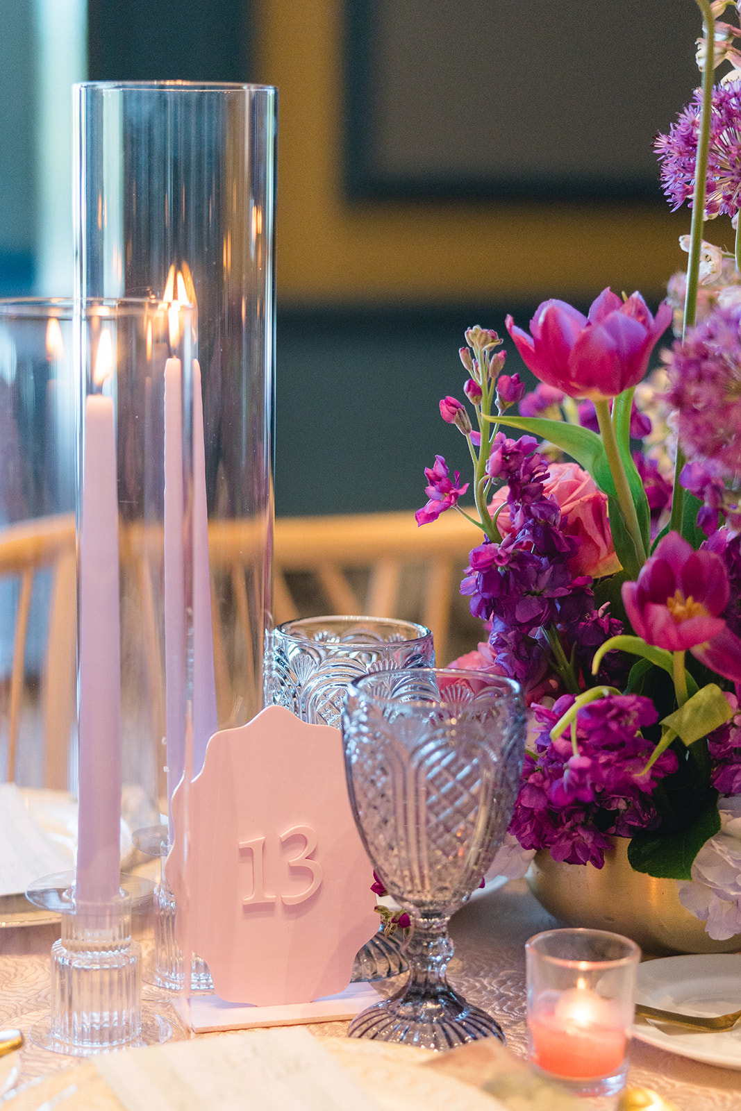 pink table numbers on tablescape by candles and flowers