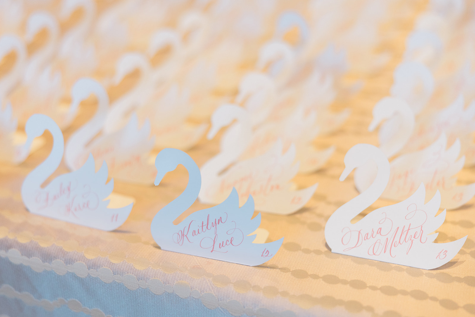 die-cut swan escort cards with pink calligraphy for Wed Society Nashville Book of Weddings Event with Marble Artwork and Swan Details