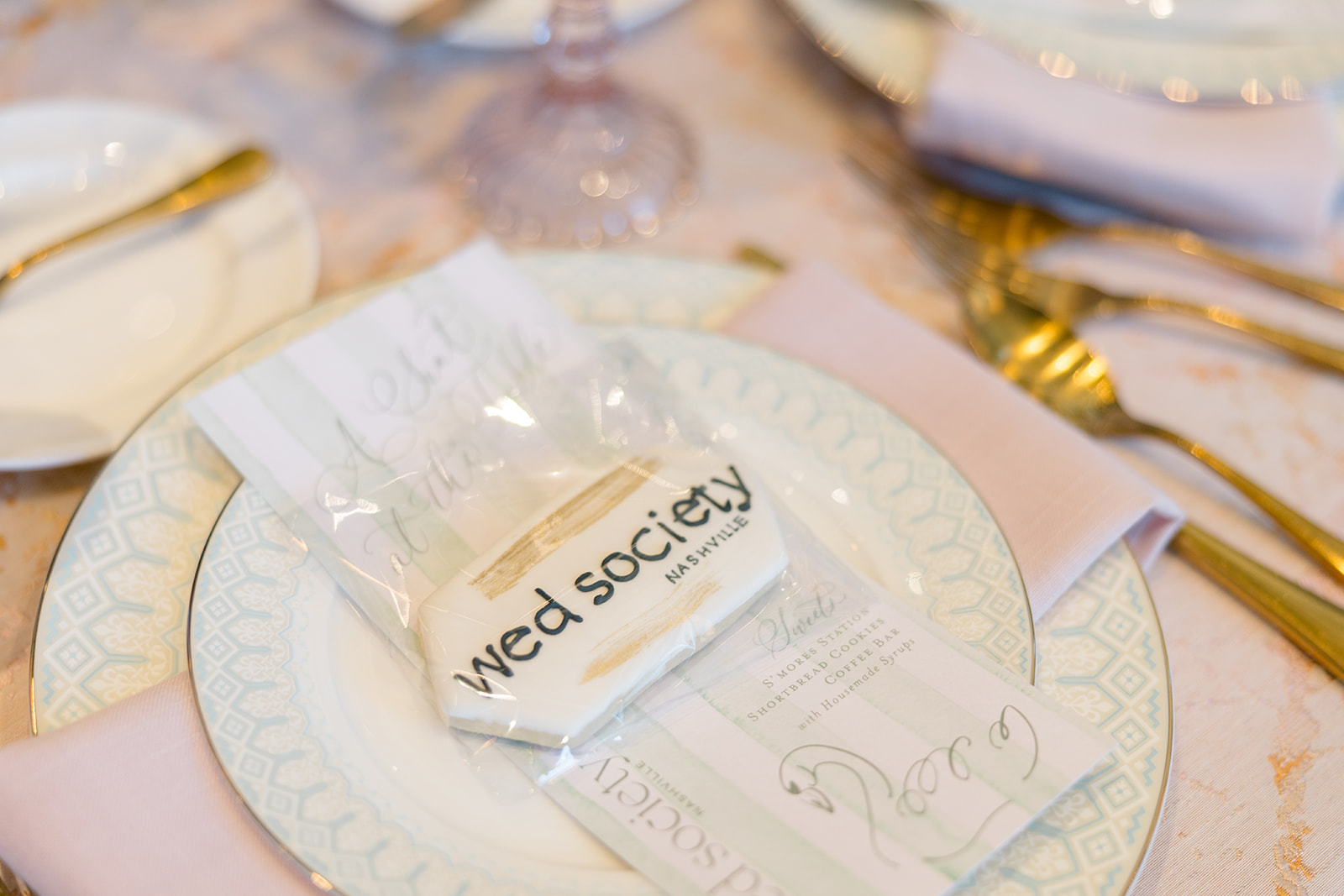 Wed society sugar cookie sits a top custom menu with swan sketch