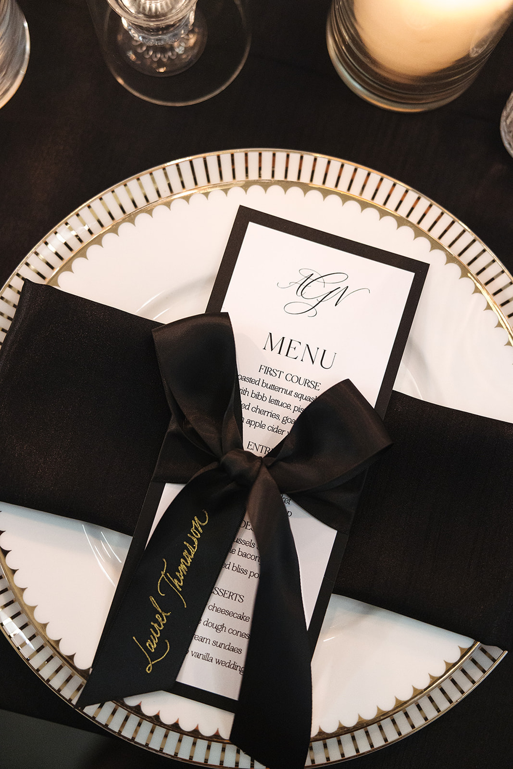 formal menu with black ribbon place card with gold calligraphy tied on menu 